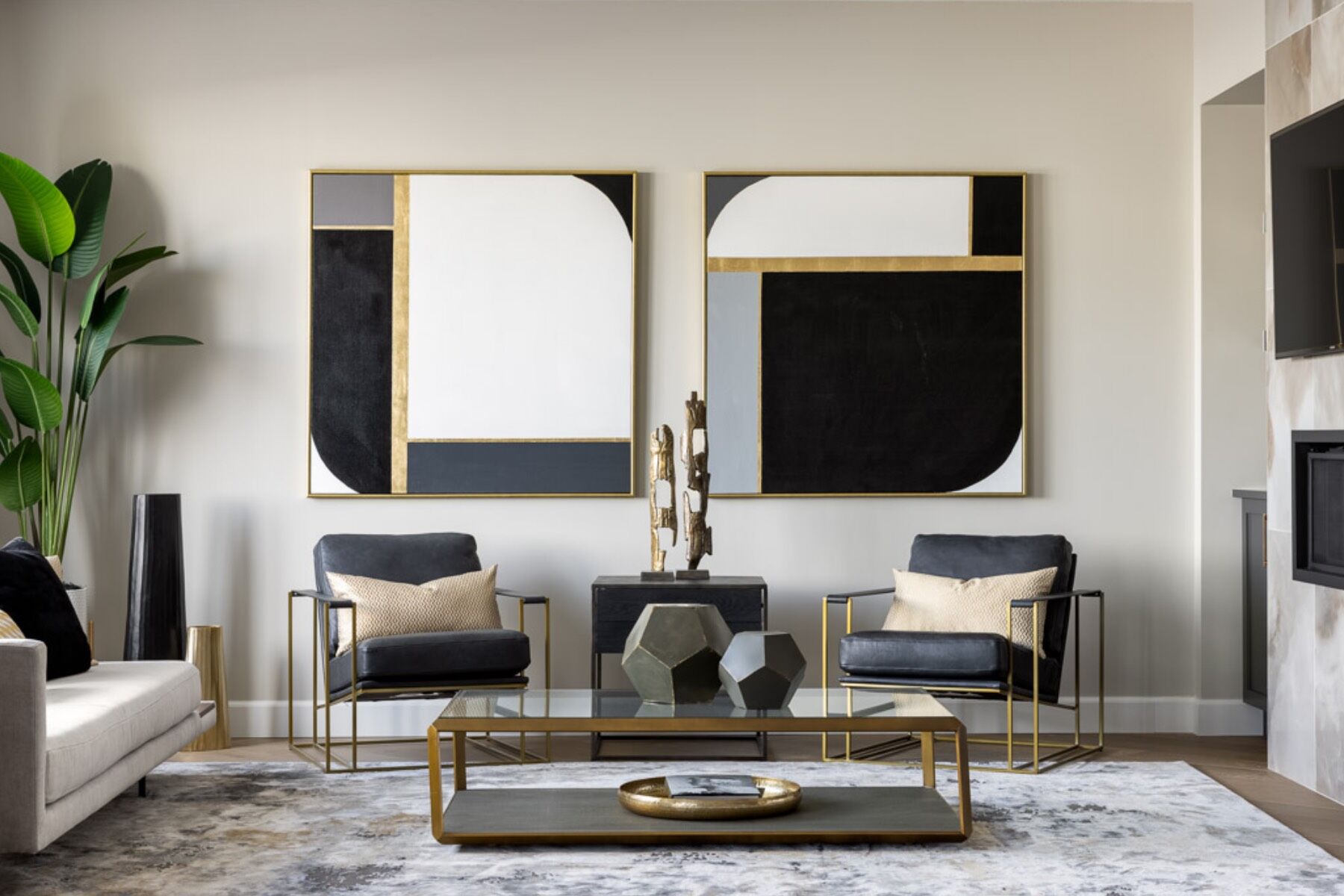 Seating space with black chairs and neutral abstract art on walls.