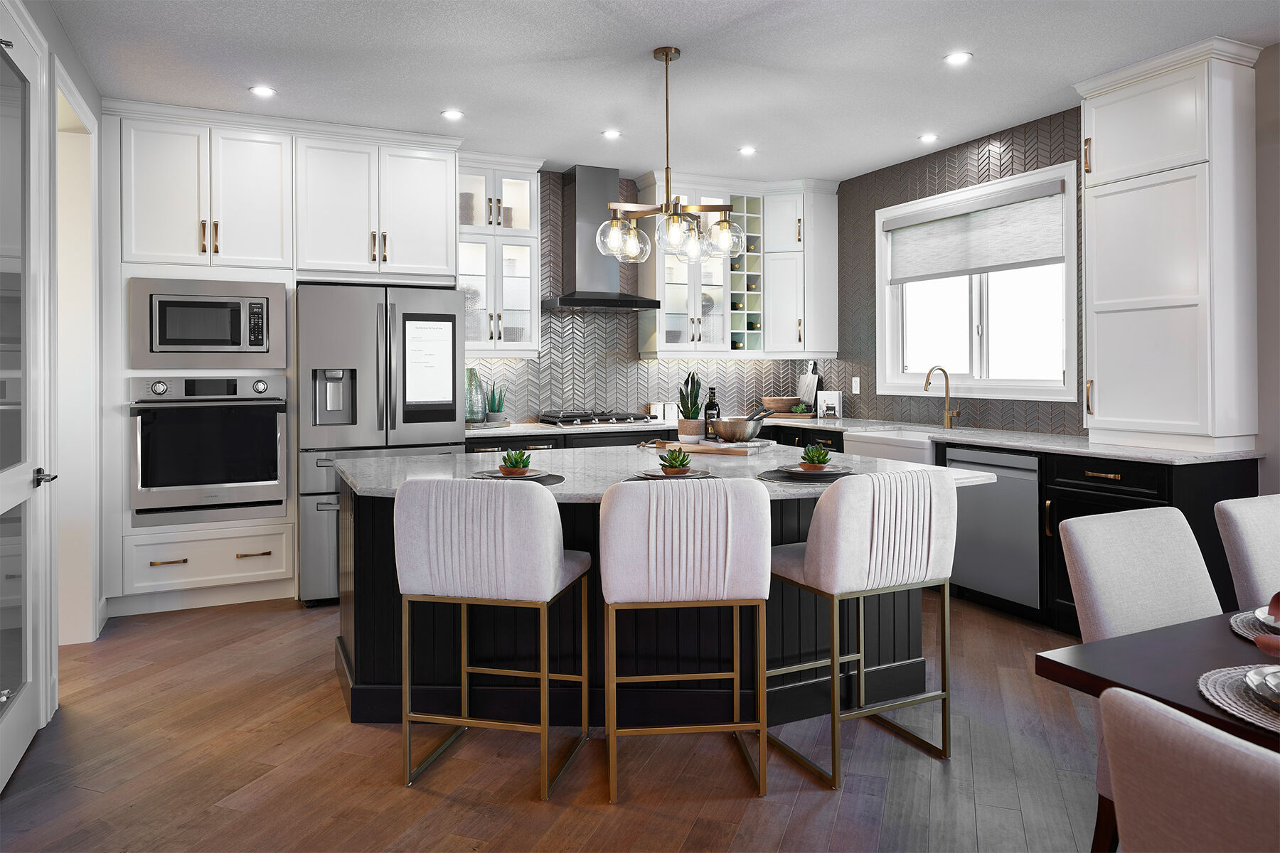 Kitchen with white cabinets and dark hardwood floors and dark central island.