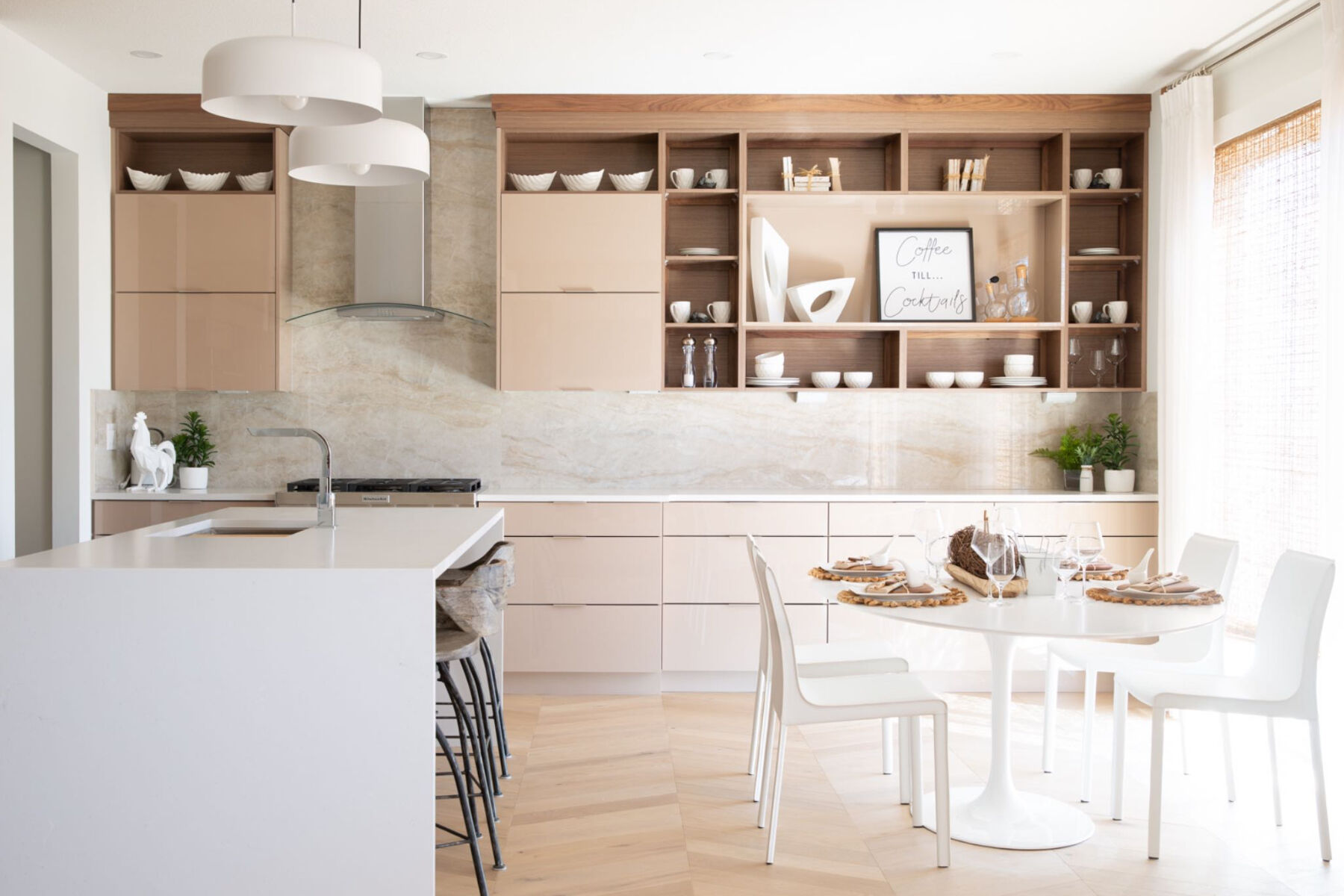 Kitchen and dining area with beige cabinets and drawers, and a white island and dining set.