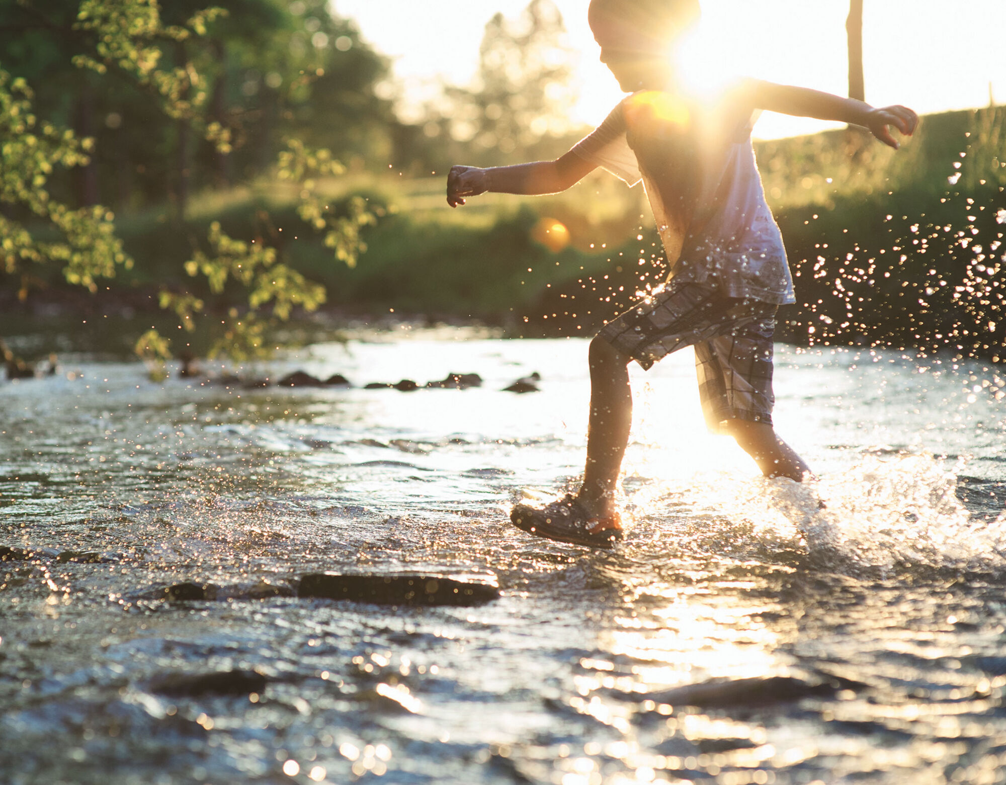 A child runs through a shallow body of water.