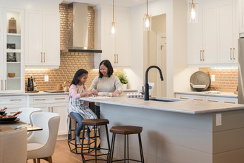L-Shaped Kitchen with kitchen island, refrigerator, pendant light, white cabinets