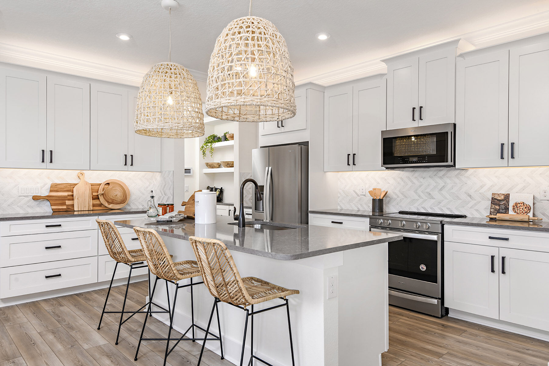 Venice townhome kitchen with breakfast bar and island, white cabinets, backsplash, model