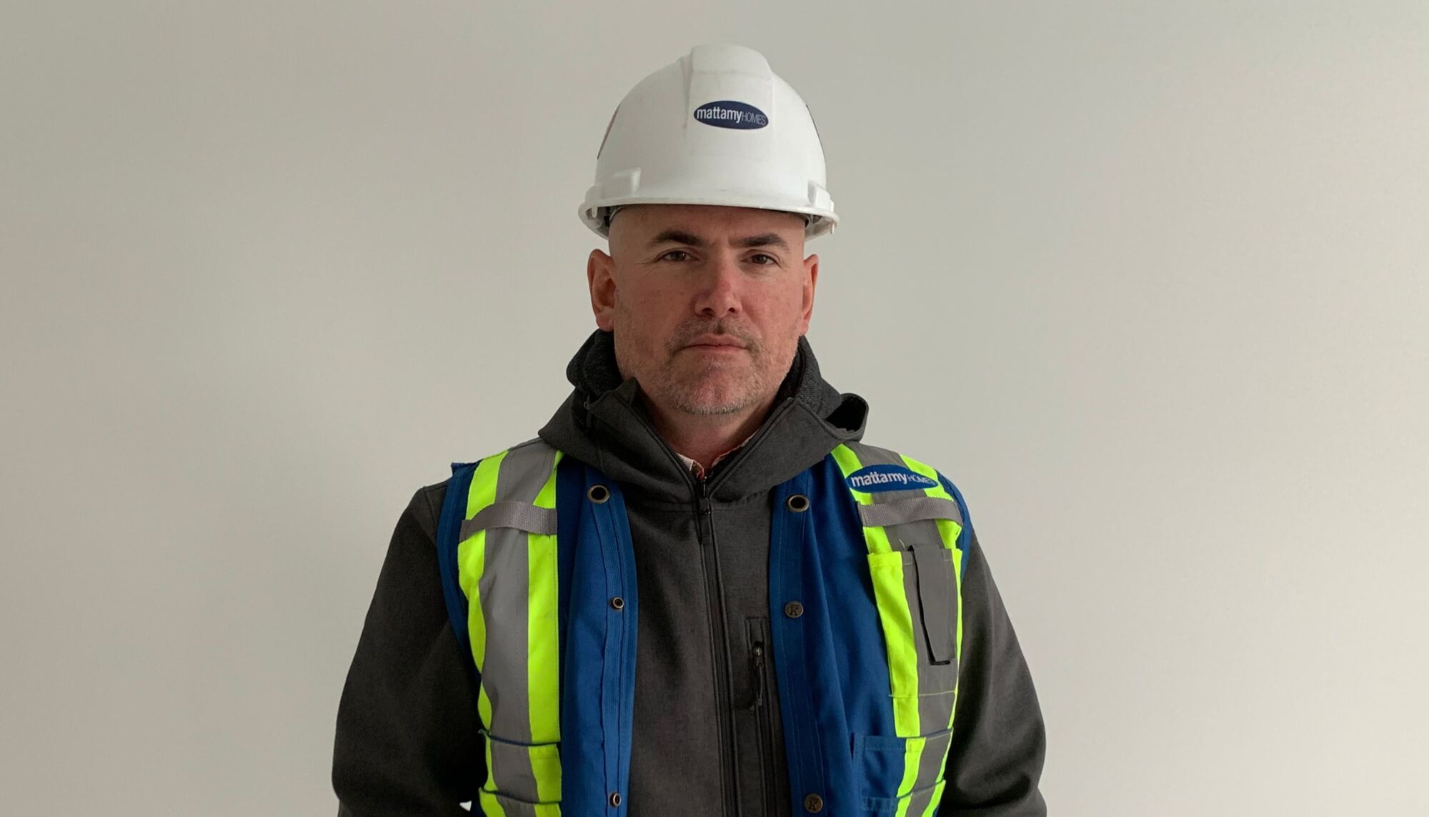 Male indoors wearing safety vest and hard hat