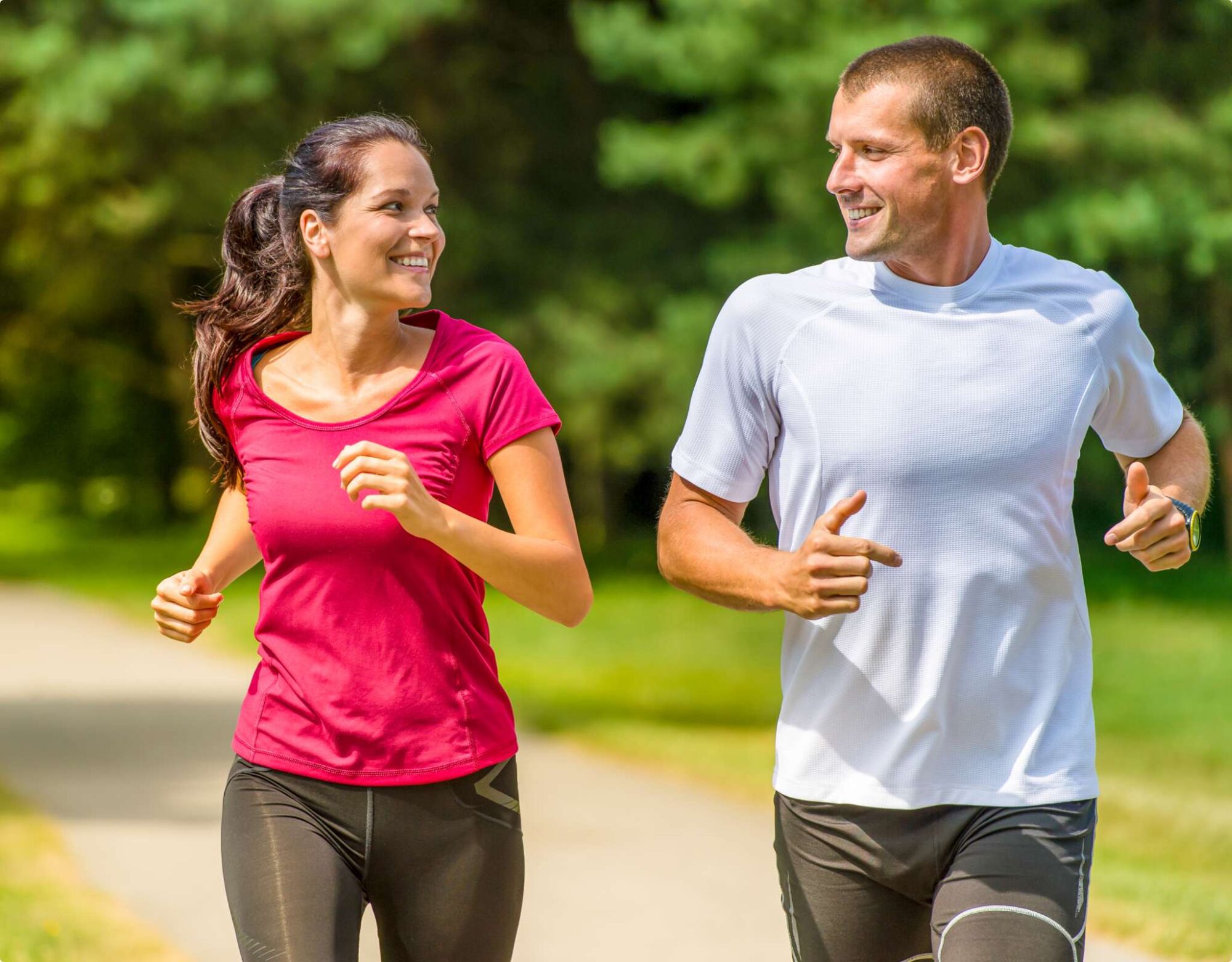 A man and woman running beside each other and looking at each other. 