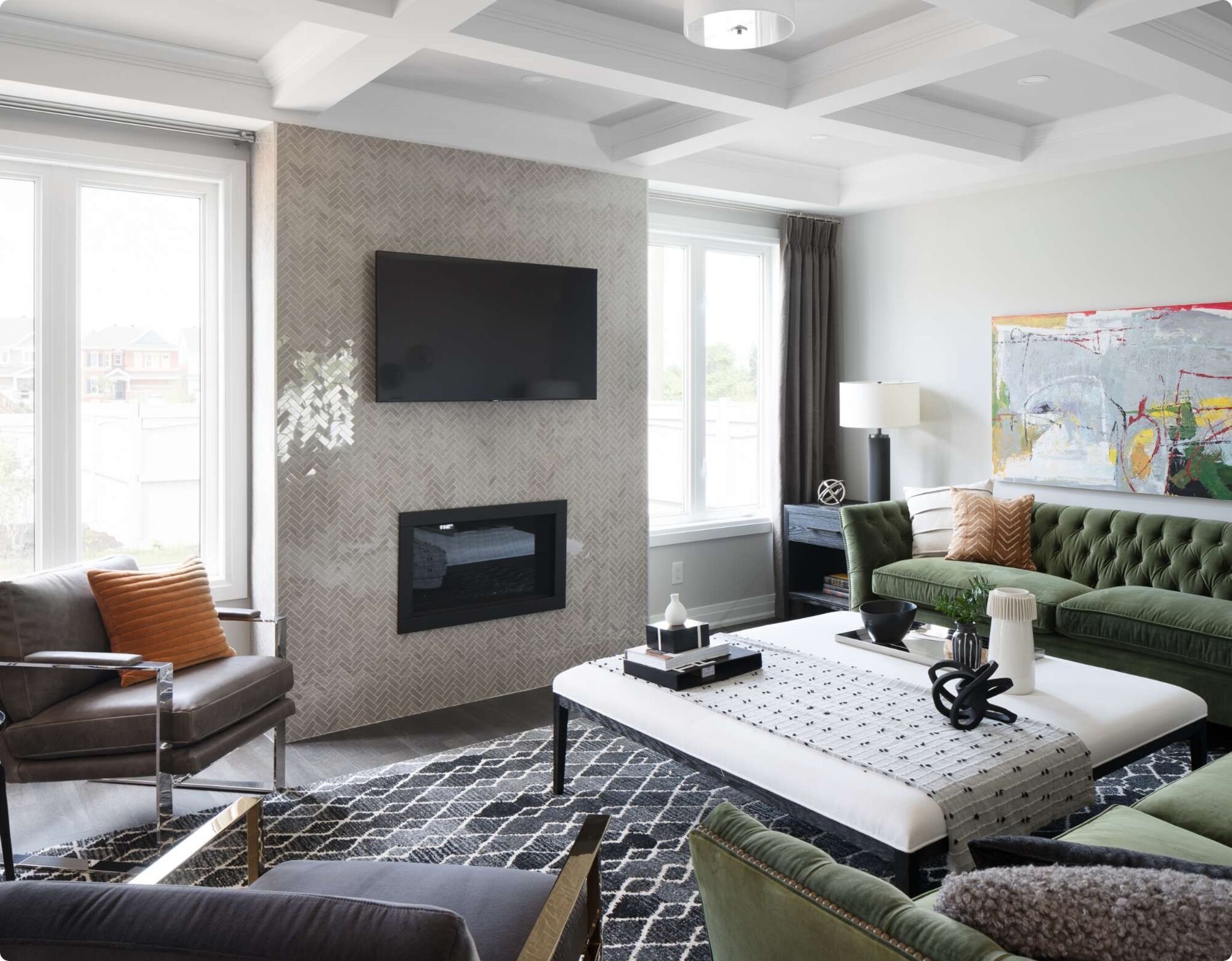A living room with a green couch, taupe accents and a fireplace.