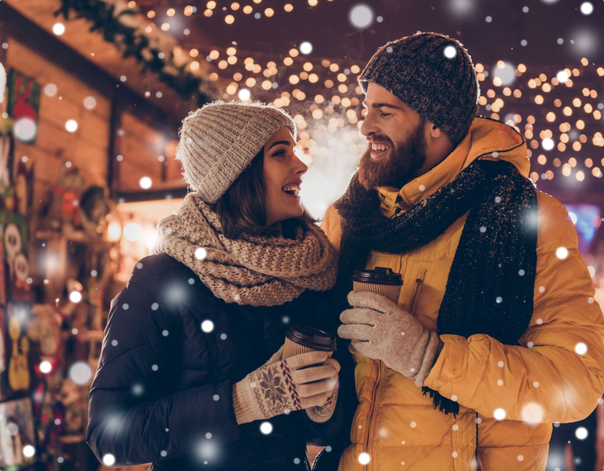 A couple embracing under festive lights.