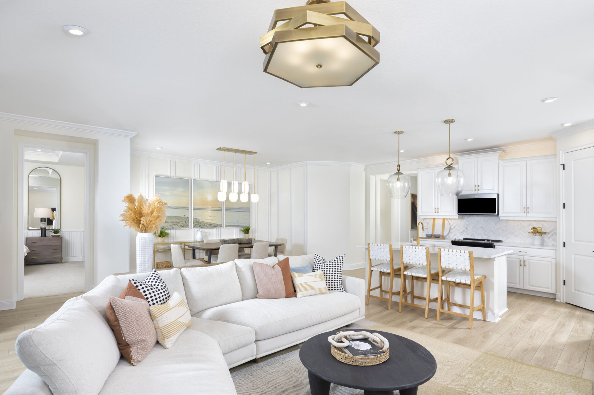  Greatroom with pendant light, door, mirror, rug, cooktop, white cabinets, raised panel cabinets and wood flooring