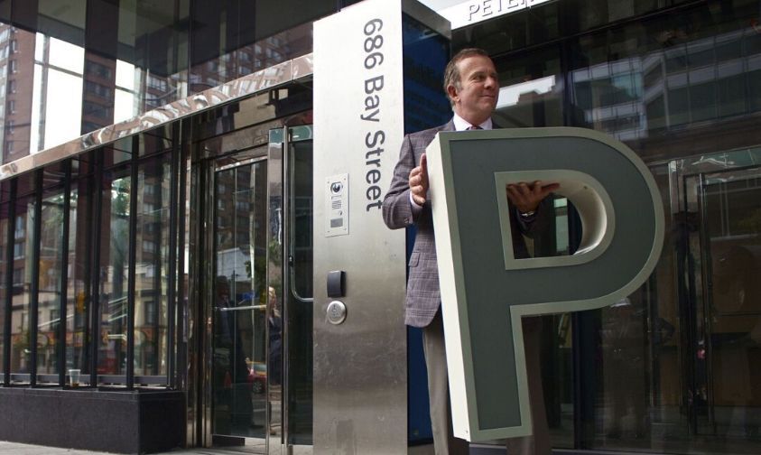 Founder of Mattamy Homes, Peter Gilgan, standing outside of the SickKids' Peter Gilgan Centre for Research and Learning holding a very large letter "P". 