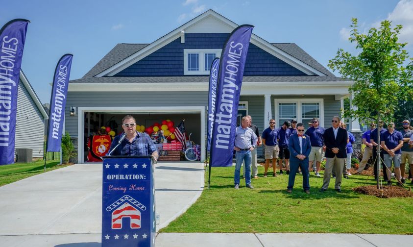 Wounded veteran standing at podium outside of his new single-family Mattamy home, which was gifted to him through the Operation: Coming Home program.