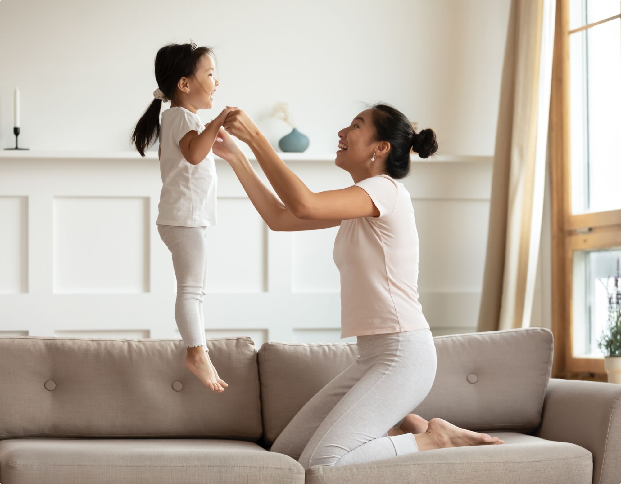 A mother playing with her daughter on a couch