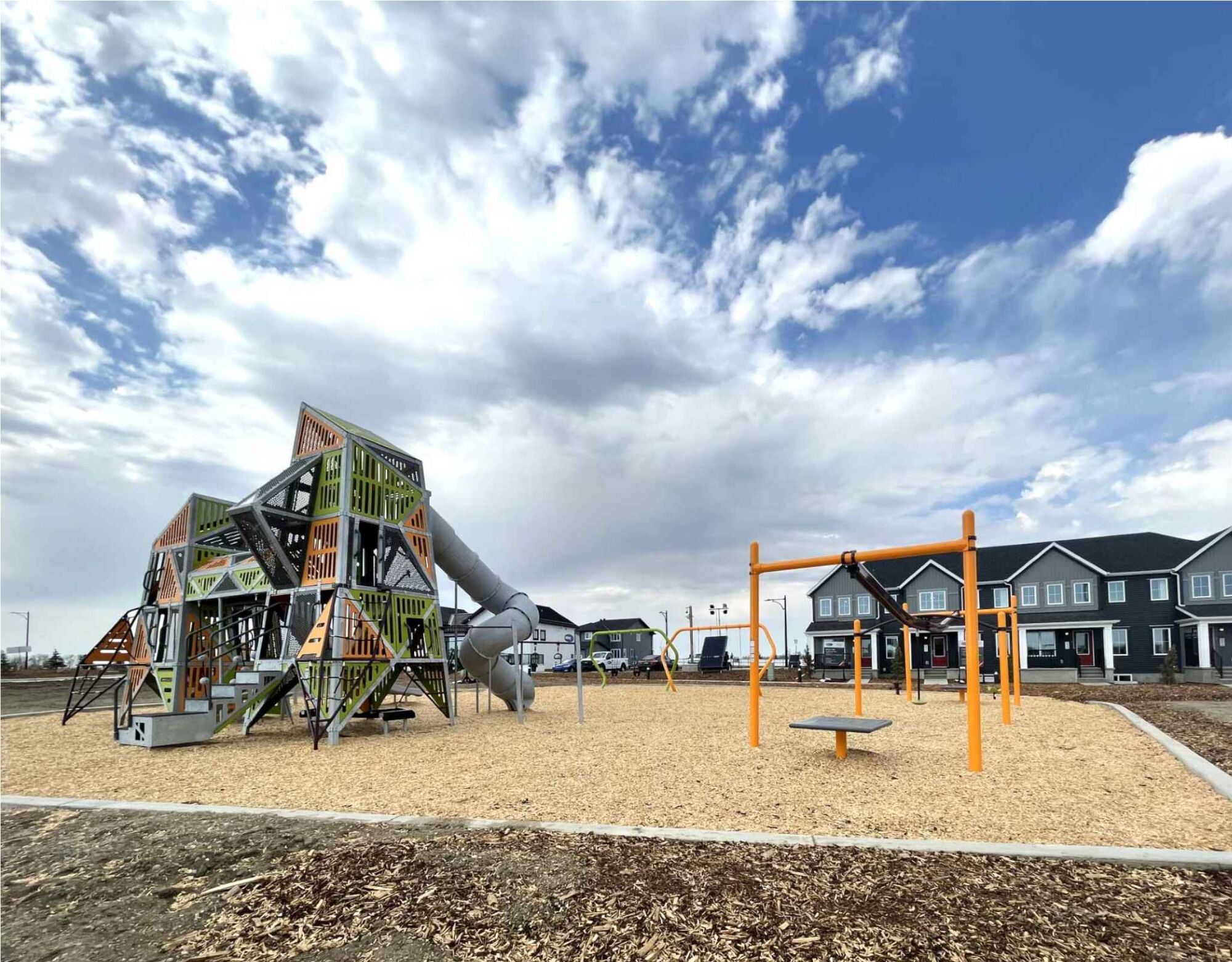 Playground amenity with sky and houses behind 