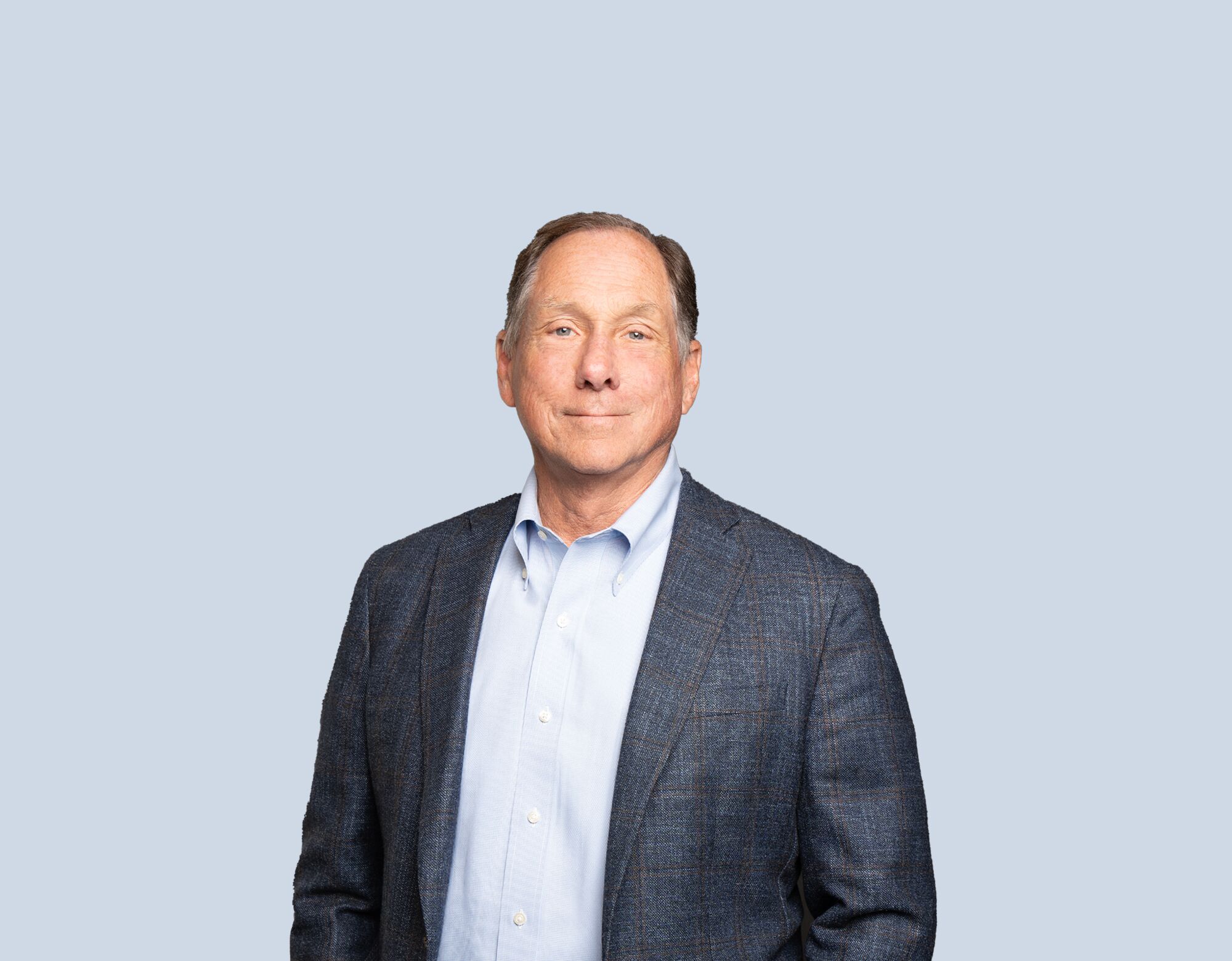 Larry Nicholson, member of Mattamy Asset Management's Board of Directors, wearing a blue blazer and smiling in front of a blue background