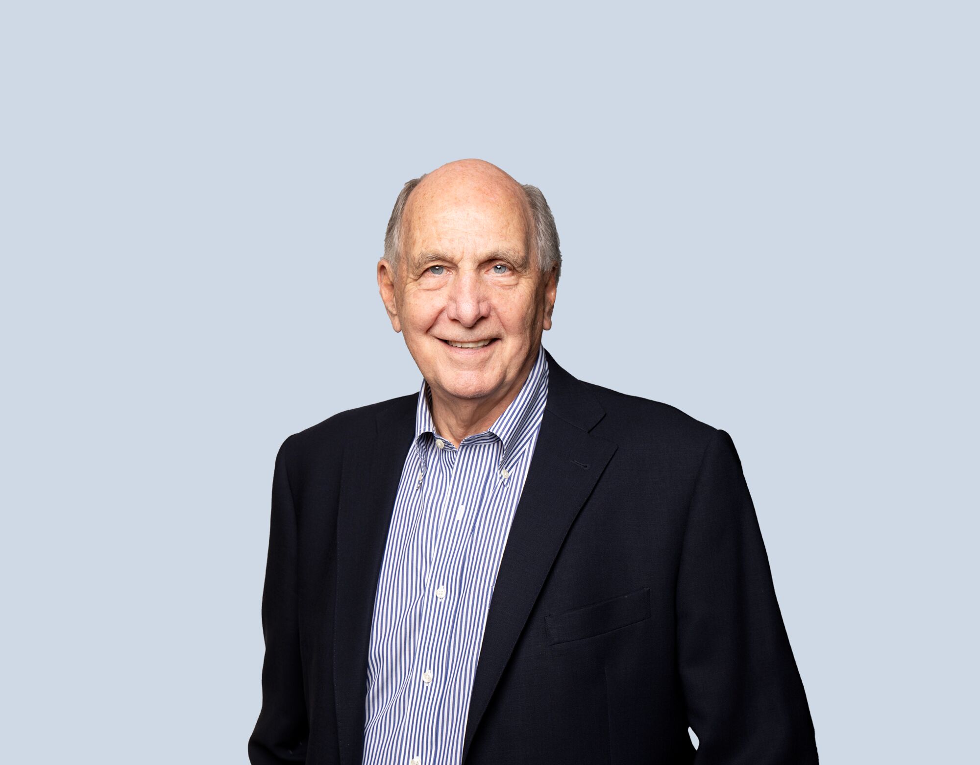 David Williams, member of Mattamy Asset Management's Board of Directors, wearing a black blazer and smiling in front of a blue background