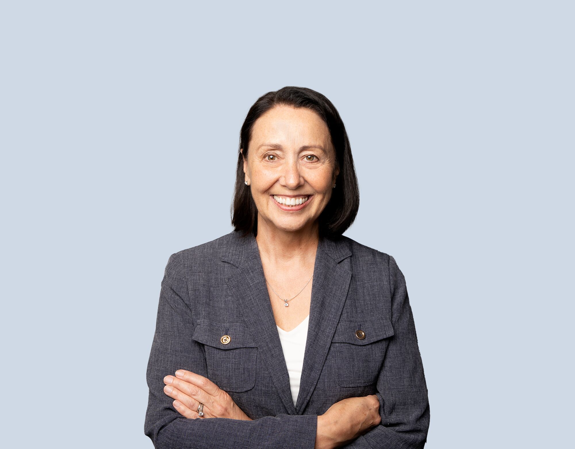 Mary Federau, member of Mattamy Asset Management's Board of Directors, wearing a grey blazer and smiling in front of a blue background