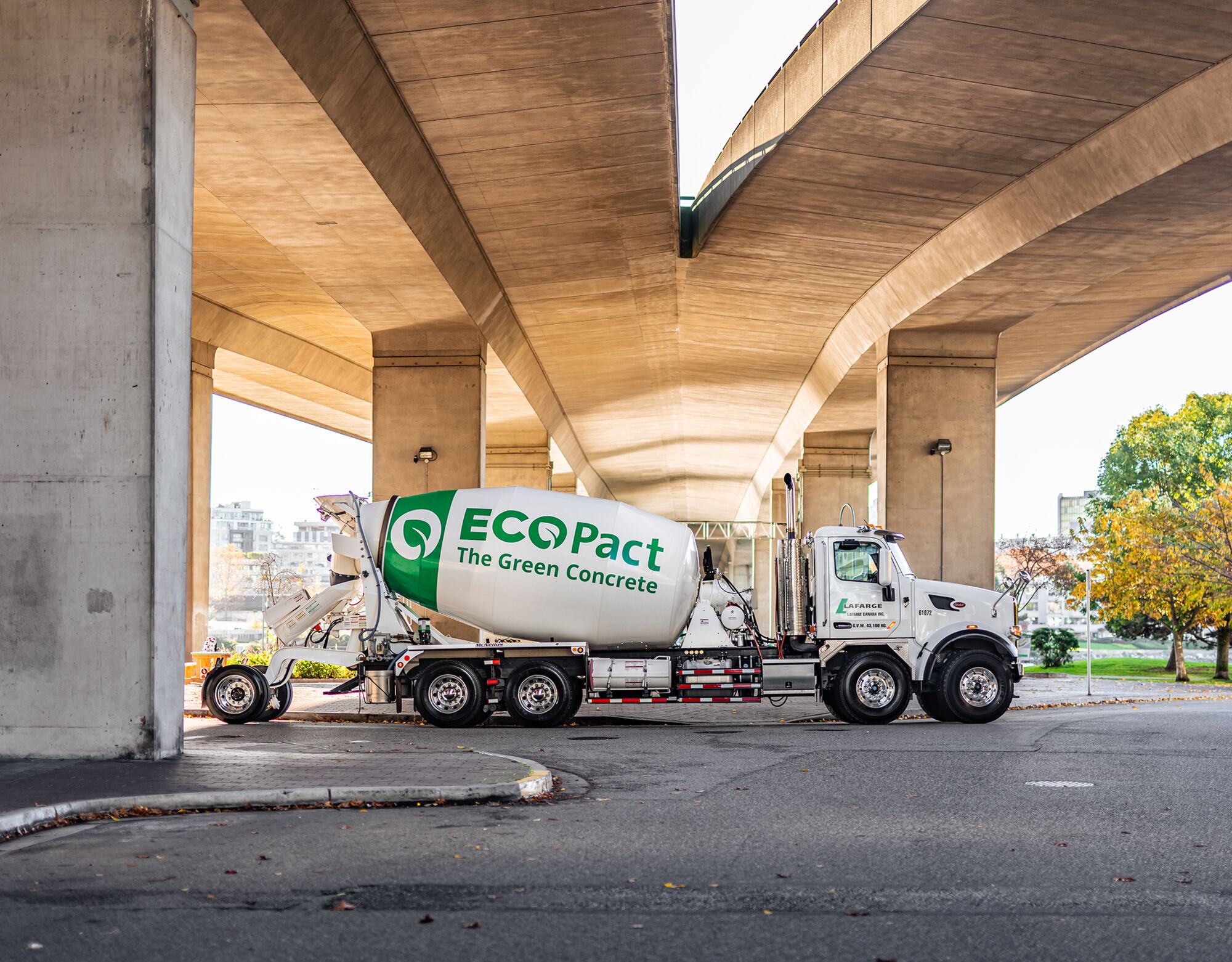 Lafarge white concrete truck parked under a bridge with green ECOPact logo on the back